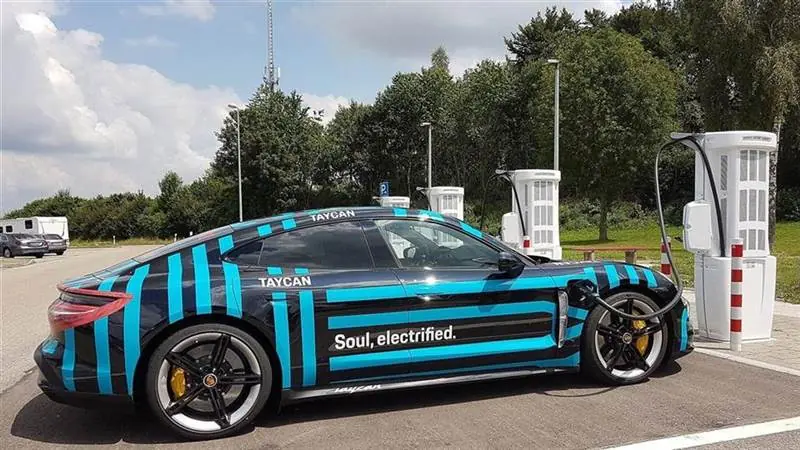 A Porsche Taycan electric car connected to a public DC charging station