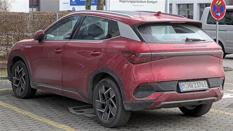A red BYD Atto 3 electric crossover with a Munich license plate photographed from the rear on a street in Stuttgart, Germany