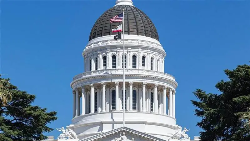 The California State Capitol building with its dome and flags in Sacramento