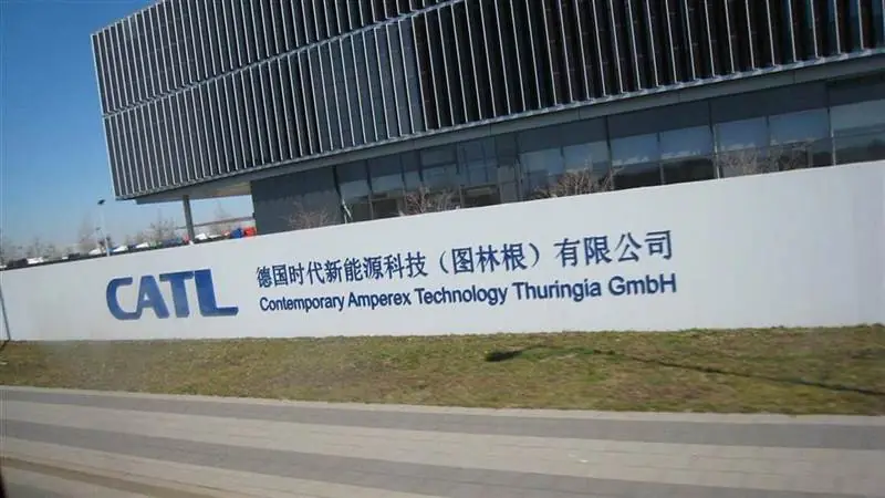 Exterior of CATL's battery plant in Arnstadt, Germany, with a white perimeter wall carrying the CATL logo and Contemporary Amperex Technology Thuringia GmbH lettering
