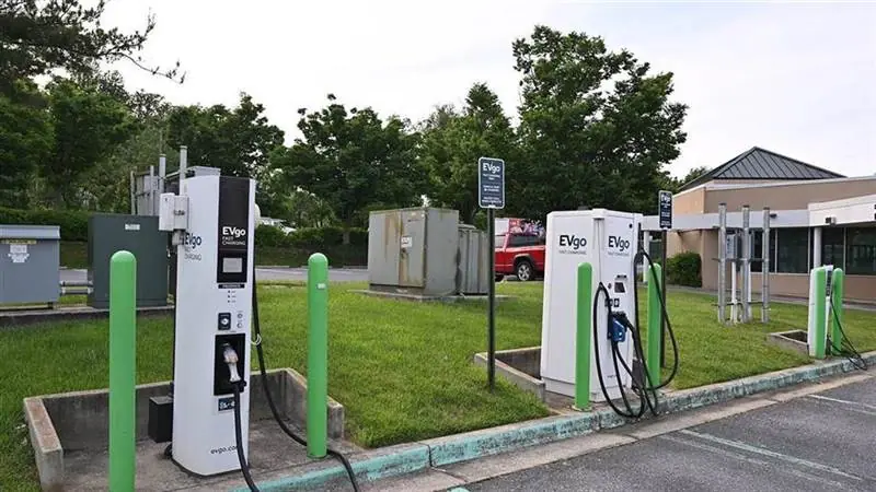 An EVgo public fast-charging station with charge cables in a suburban parking lot