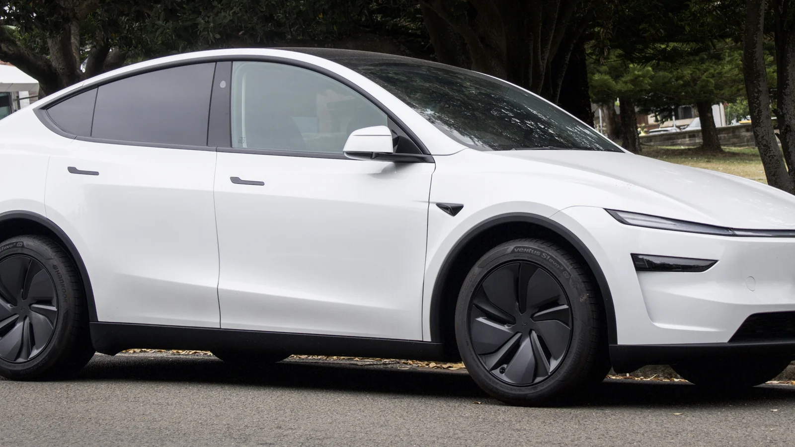 White refreshed Tesla Model Y parked outdoors; illustrative production vehicle, not a photograph of the Austin Robotaxi fleet.