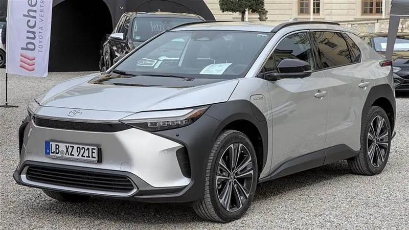 A white Toyota bZ4X electric SUV photographed at a German auto show